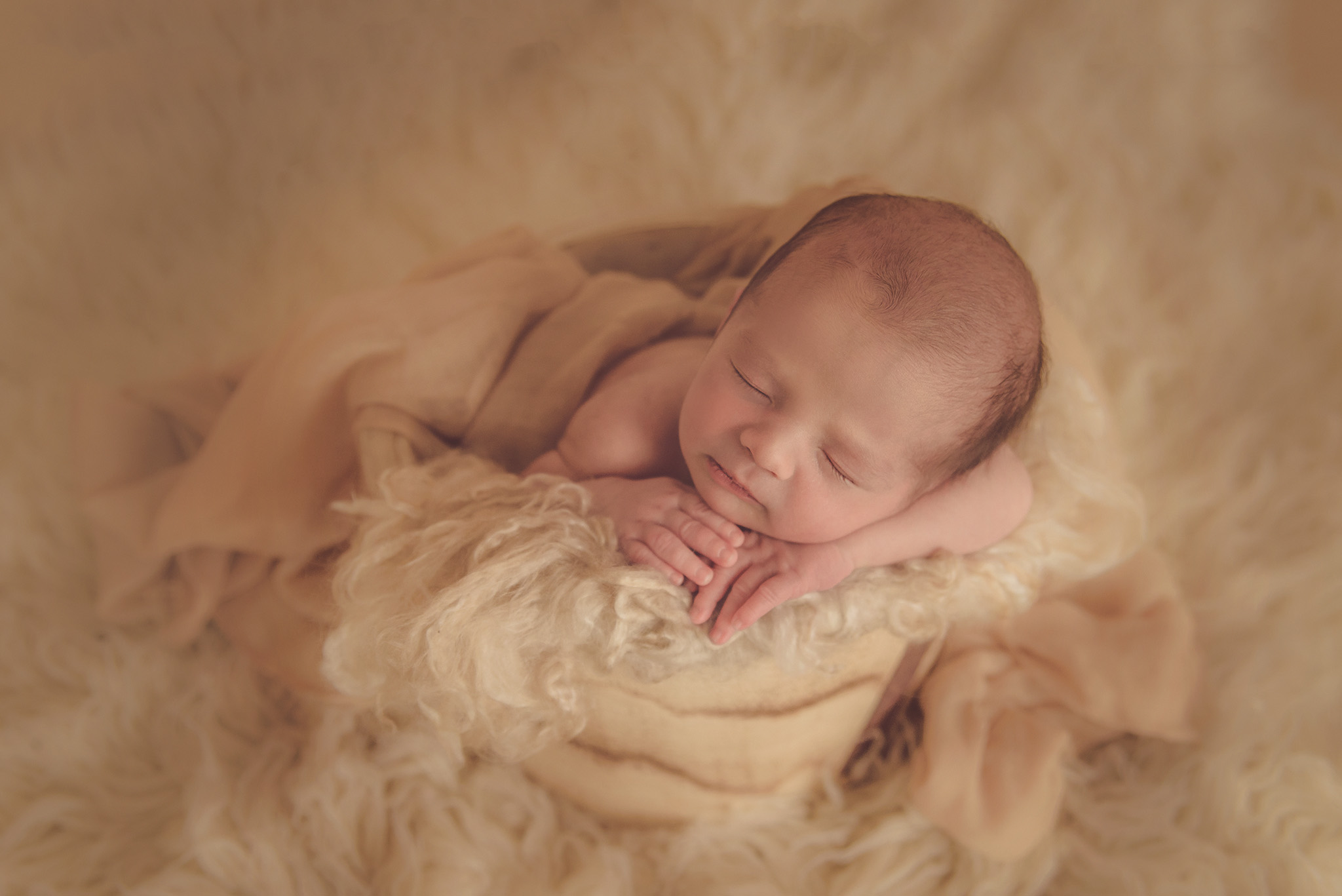 bébé qui dort dans la laine en séance photo