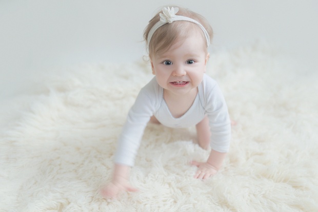 portrait d'un enfant qui sourit sur un tapis au fond blanc sur Lille
