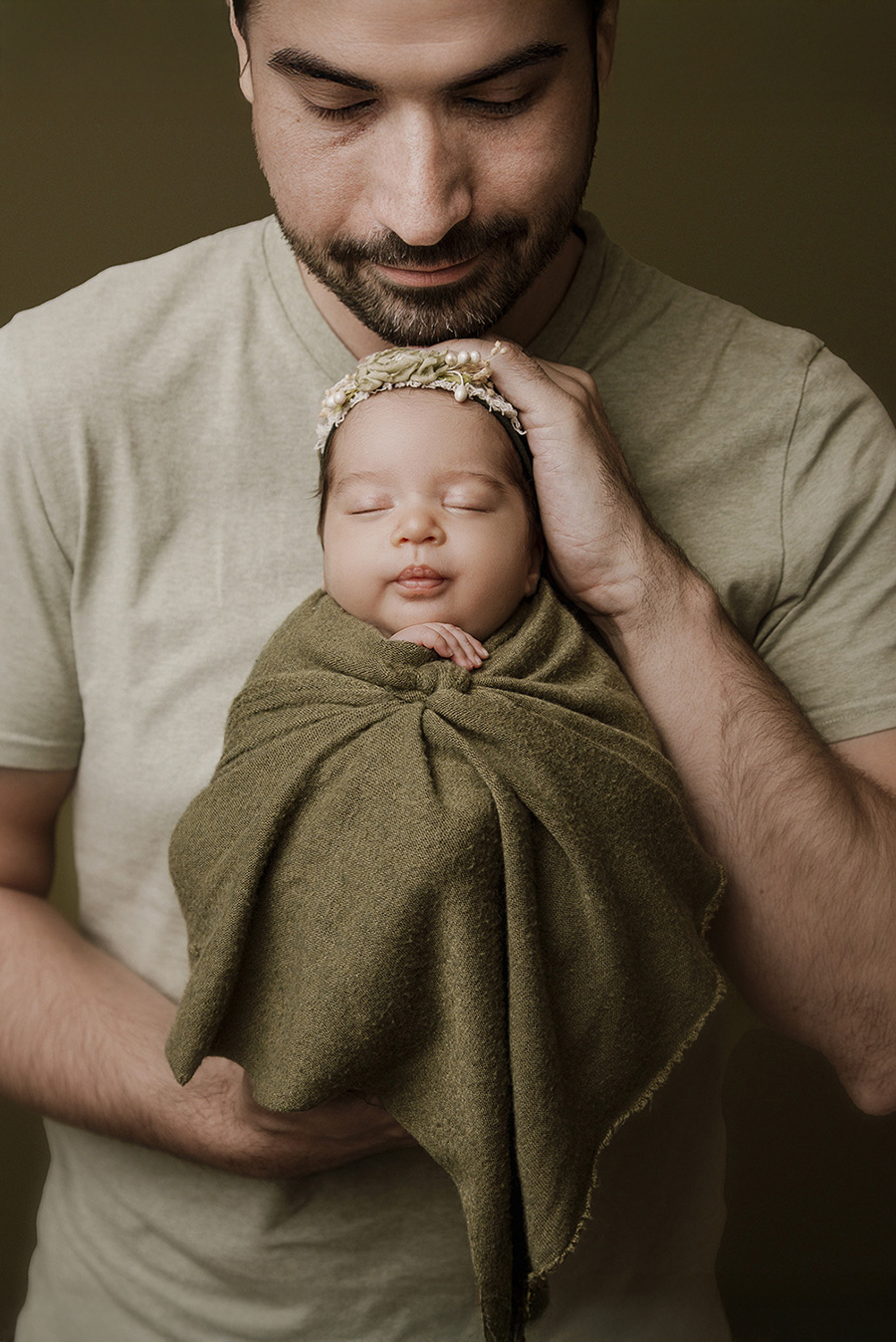 shooting d'un papa qui porte son bébé lors d'une séance photo naissance en studio sur Bondues près de Lille