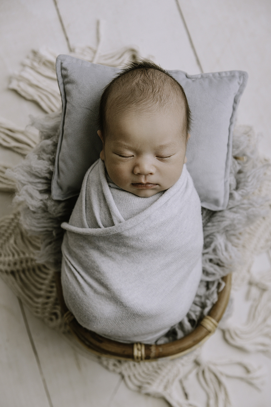 portrait d'un bébé emmailloté dans un tissu bleu ciel à Lille