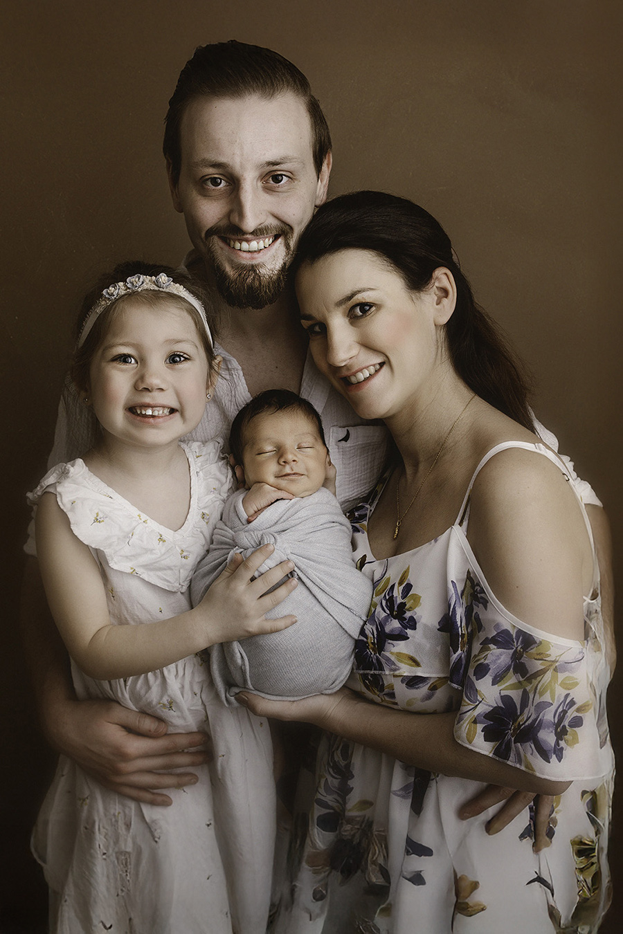 portrait d'une famille qui caline son bébé lors d'une séance photo naissance en studio sur Tourcoing