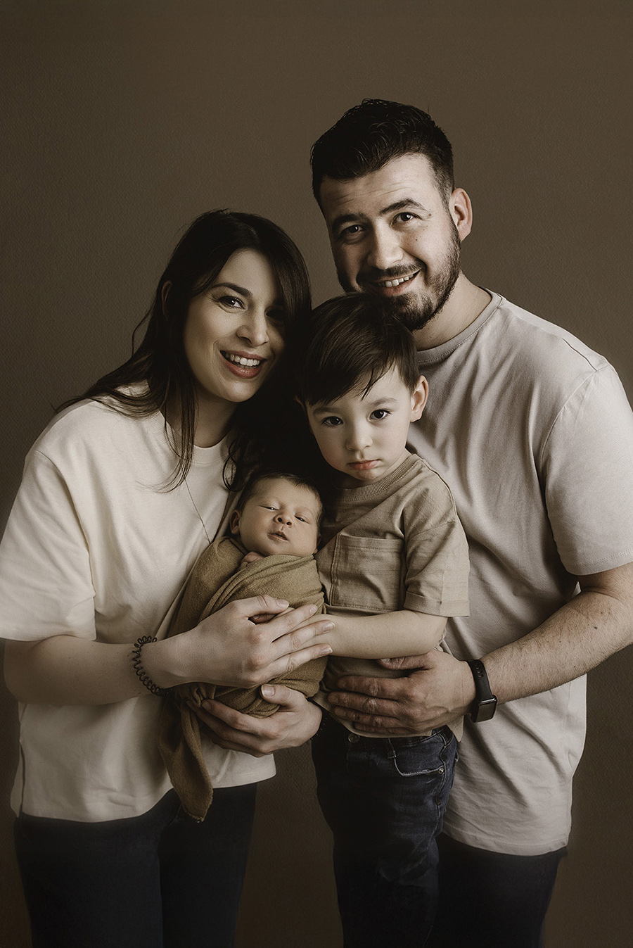 photo d'une famille qui caline son bébé lors d'une séance photo naissance en studio sur Tourcoing