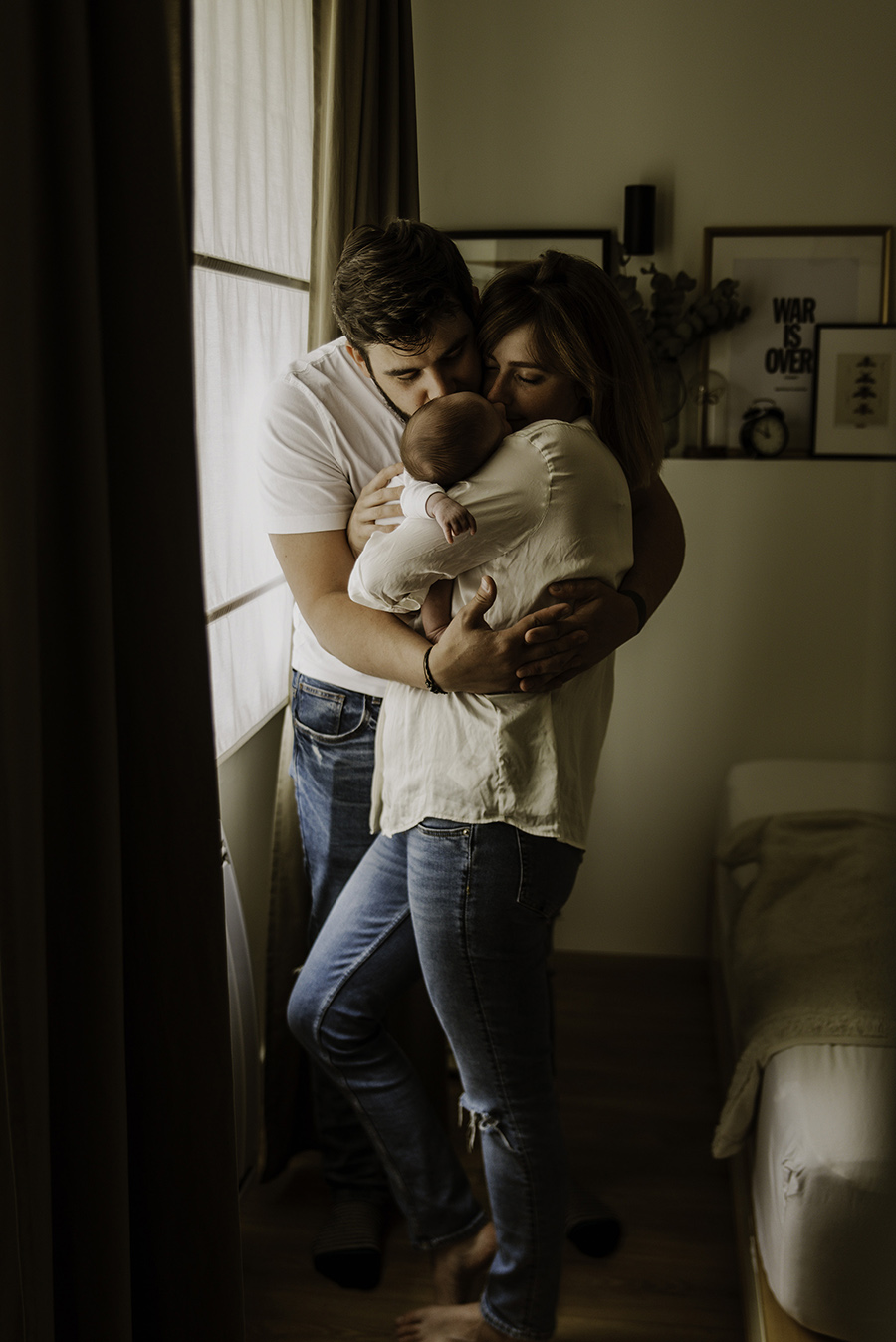 photo de parents qui enlacent leur bébé lors d'une séance photo naissance à domicile sur Roubaix Tourcoing